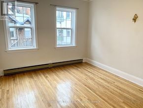 Stratford multi-family for rent - A room with wooden flooring and two windows.