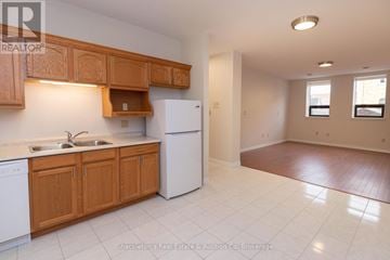 Stratford multi-family for rent - A kitchen with wooden cabinets and white appliances.