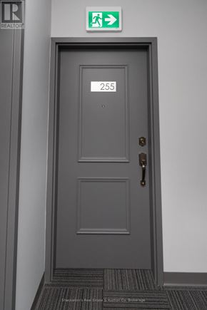 Stratford multi-family for rent - A grey door with a number 255 on it and a green exit sign above it.
