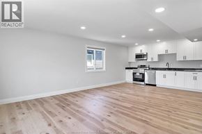 Windsor apartment for rent - A spacious kitchen with white cabinets and a wooden floor.