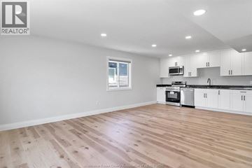 Windsor apartment for rent - A spacious kitchen with white cabinets and a wooden floor.