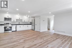 Windsor apartment for rent - A spacious kitchen with white cabinets and a wooden floor.