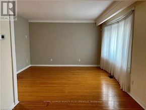 St. Catharines (Bunting/Linwell) apartment for rent - A room with wooden flooring and a window with white curtains.