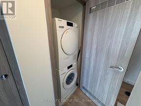 Toronto (Waterfront Communities) condo for rent - A washer and dryer are built into a wall in a small room.