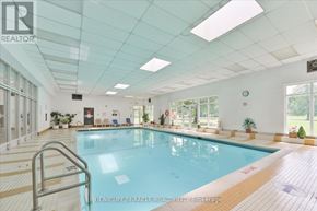 Toronto (L'amoreaux) condo for rent - A large indoor swimming pool with a glass ceiling and tiled floor.