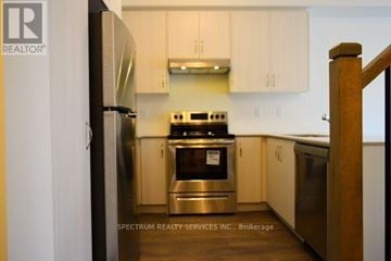 Milton (Fo Ford) townhouse for rent - A kitchen with a stove and refrigerator.