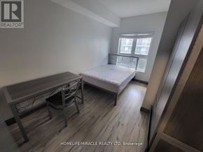 Waterloo condo for rent - A bedroom with a bed, desk, and chair.
