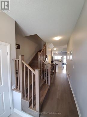 Lincoln (Beamsville) townhouse for rent - A hallway with a staircase and a door on the left.