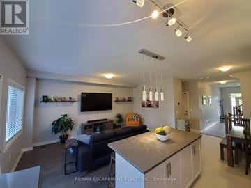 Lincoln (Beamsville) townhouse for rent - A modern living room with a grey couch and a flat screen TV mounted on the wall.