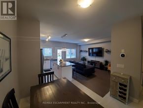 Lincoln (Beamsville) townhouse for rent - A living room with a couch, a chair, and a television.