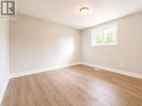 London East (East I) apartment for rent - A room with wooden flooring and a window showing greenery outside.