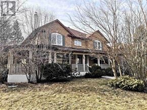 Markham (Unionville) apartment for rent - A large brick house with a porch and a tree in front.