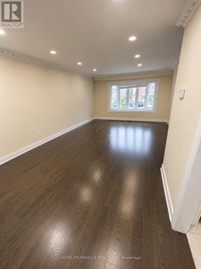 Brampton (Madoc) apartment for rent - A spacious room with wooden flooring and a window letting in natural light.
