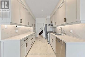 Richmond Hill (Rouge Woods) townhouse for rent - A modern kitchen with white cabinets and a marble countertop.