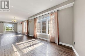 Richmond Hill (Rouge Woods) townhouse for rent - A spacious room with wooden floors and large windows with curtains.