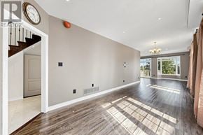 Richmond Hill (Rouge Woods) townhouse for rent - A spacious room with wooden flooring and a staircase on the left side.