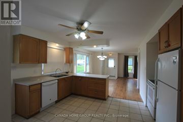 Innisfil apartment for rent - A kitchen with wooden cabinets and a white dishwasher.