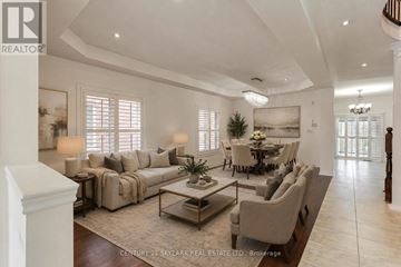 Brampton (Vales Of Castlemore) apartment for rent - A spacious living room with a sofa set, a coffee table, and a dining table with chairs.