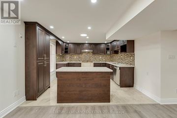 Brampton (Vales Of Castlemore) apartment for rent - A modern kitchen with wooden cabinets and a central island.