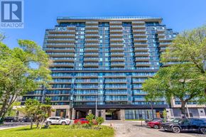 Mississauga (Cooksville) condo for rent - A modern multi-story building with a glass facade and a parking lot in front.