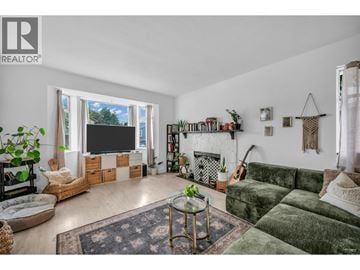 Maple Ridge apartment for rent - A living room with a green couch and a fireplace.