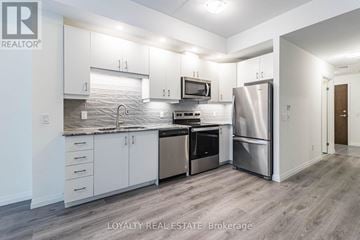Kitchener condo for rent - A modern kitchen with white cabinets and stainless steel appliances.