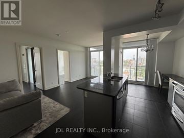 Toronto (Rosedale-Moore Park) condo for rent - A spacious kitchen and living room with a grey sofa and a chandelier.