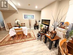 Wasaga Beach apartment for rent - A living room with a fireplace and a dining table set up.