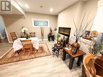 Wasaga Beach apartment for rent - A living room with a fireplace and a dining table set up.