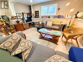 Wasaga Beach apartment for rent - A living room with a grey couch and a wooden coffee table.