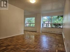 Hamilton (Durand) multi-family for rent - A room with wooden flooring and large windows.
