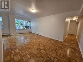 Hamilton (Durand) multi-family for rent - A room with wooden flooring and white walls.