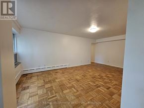 Hamilton (Durand) multi-family for rent - A room with wooden flooring and white walls.