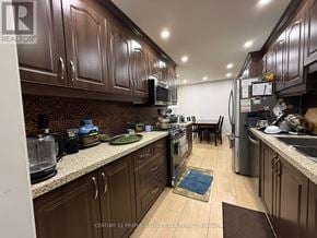 Mississauga (Meadowvale) apartment for rent - A kitchen with brown cabinets and a brick backsplash.