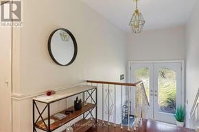 Oakville (Wo West) apartment for rent - A hallway with a round mirror on the wall and a chandelier hanging from the ceiling.