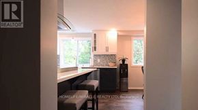 Cambridge apartment for rent - A realtor logo is on the wall of a modern kitchen.