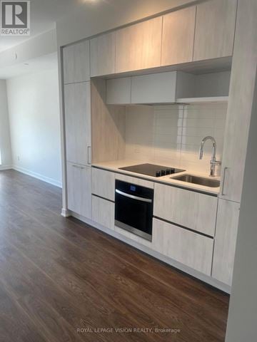 Richmond Hill (Crosby) condo for rent - A modern kitchen with white cabinets and a wooden floor.