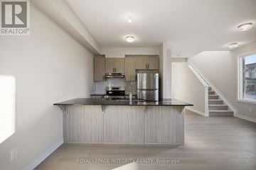 Ottawa townhouse for rent - A modern kitchen with a stainless steel refrigerator and a wooden island.