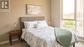 Burlington (Uptown) condo for rent - A bedroom with a large bed and a painting on the wall.
