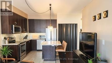 Burlington (Uptown) condo for rent - A modern kitchen with dark wood cabinets and a marble island.