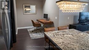 Burlington (Uptown) condo for rent - A modern kitchen with granite countertops and a chandelier.