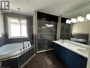 Kitchener apartment for rent - A bathroom with a tub, sink, and mirror.