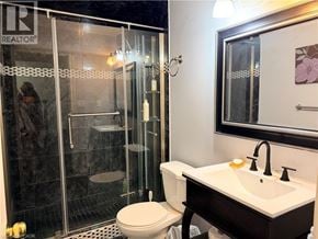 Kitchener apartment for rent - A bathroom with a toilet, sink, and shower.
