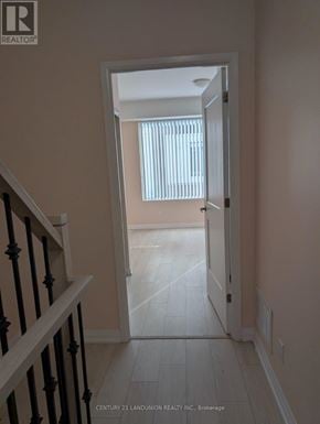 Vaughan (Concord) townhouse for rent - A hallway with a staircase on the left and a doorway leading to a room with a window.