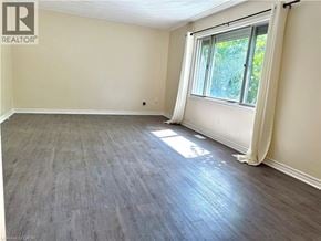 Kitchener apartment for rent - A room with a window and wooden flooring.