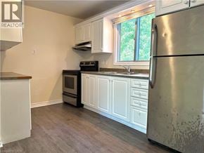 Kitchener apartment for rent - A kitchen with a refrigerator, oven, and sink.