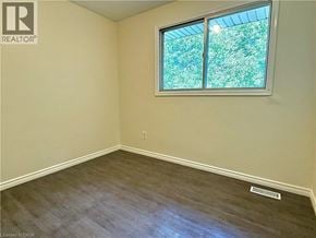 Kitchener apartment for rent - A room with a window showing greenery outside.