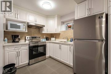 Vancouver apartment for rent - A kitchen with white cabinets and stainless steel appliances.