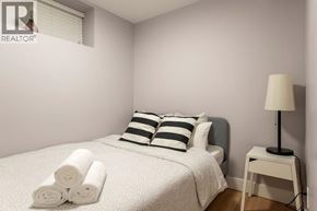 Vancouver apartment for rent - A bedroom with a bed, pillows, a lamp, and towels.