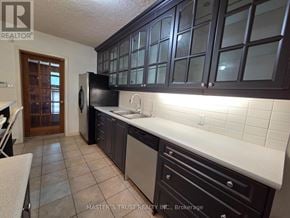 Richmond Hill (Crosby) apartment for rent - A kitchen with dark brown cabinets and a black fridge.